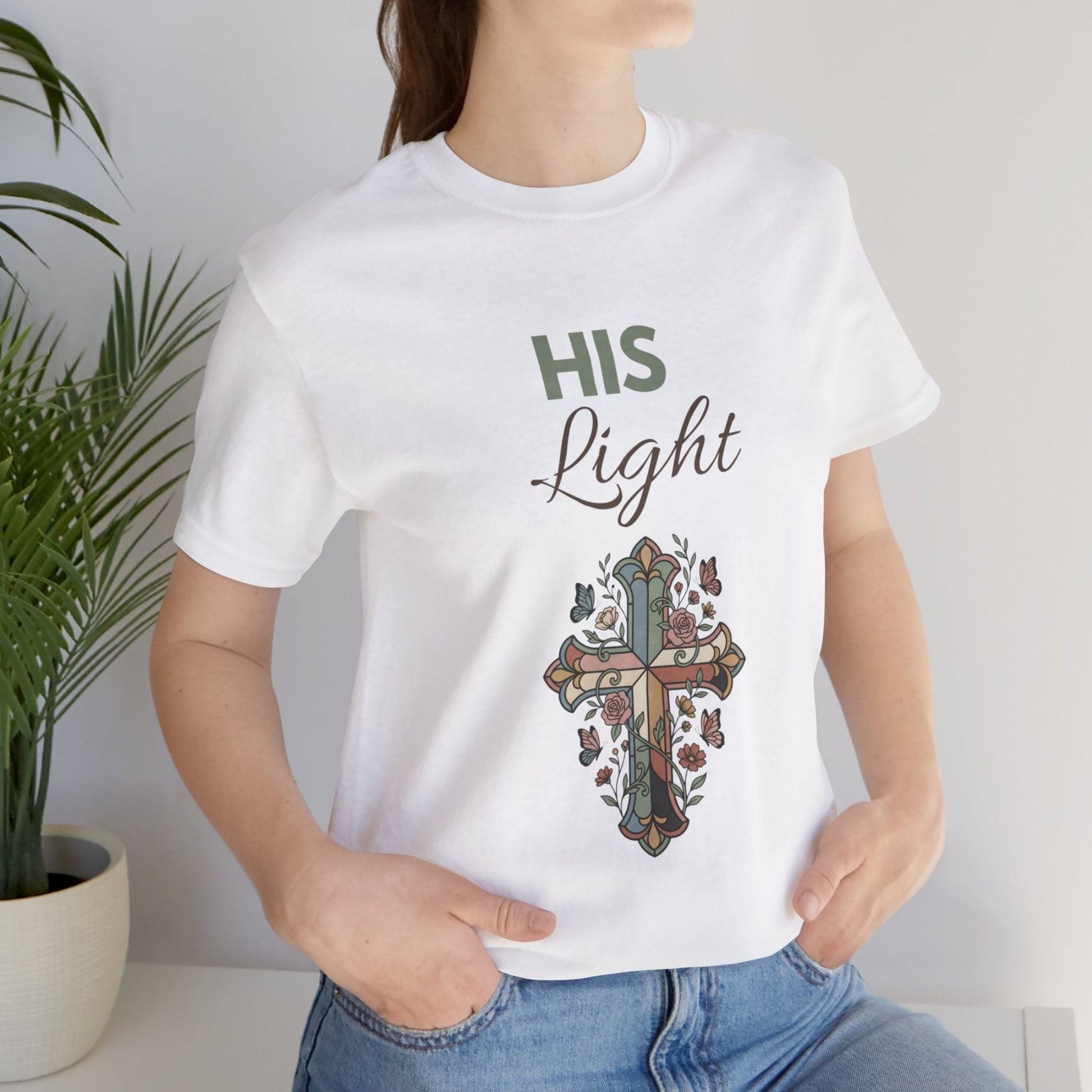 Person wearing a white t-shirt with a cross design and 'HIS Light' text.