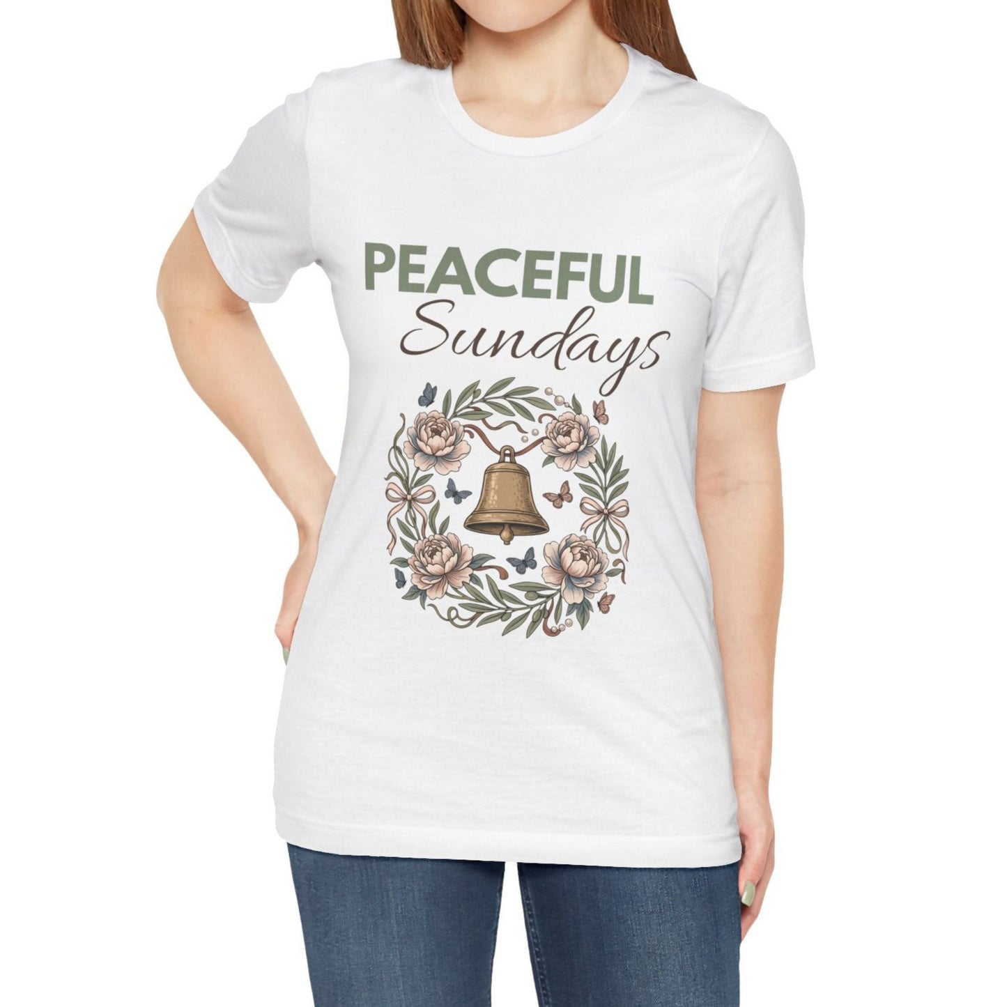White t-shirt with 'Peaceful Sundays' design featuring a bell and flowers, worn by a person.