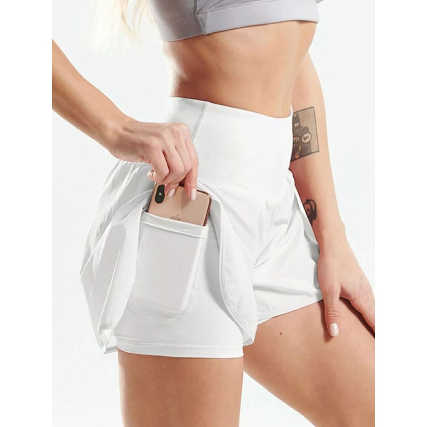 White athletic shorts with a pocket held by a person on a white background