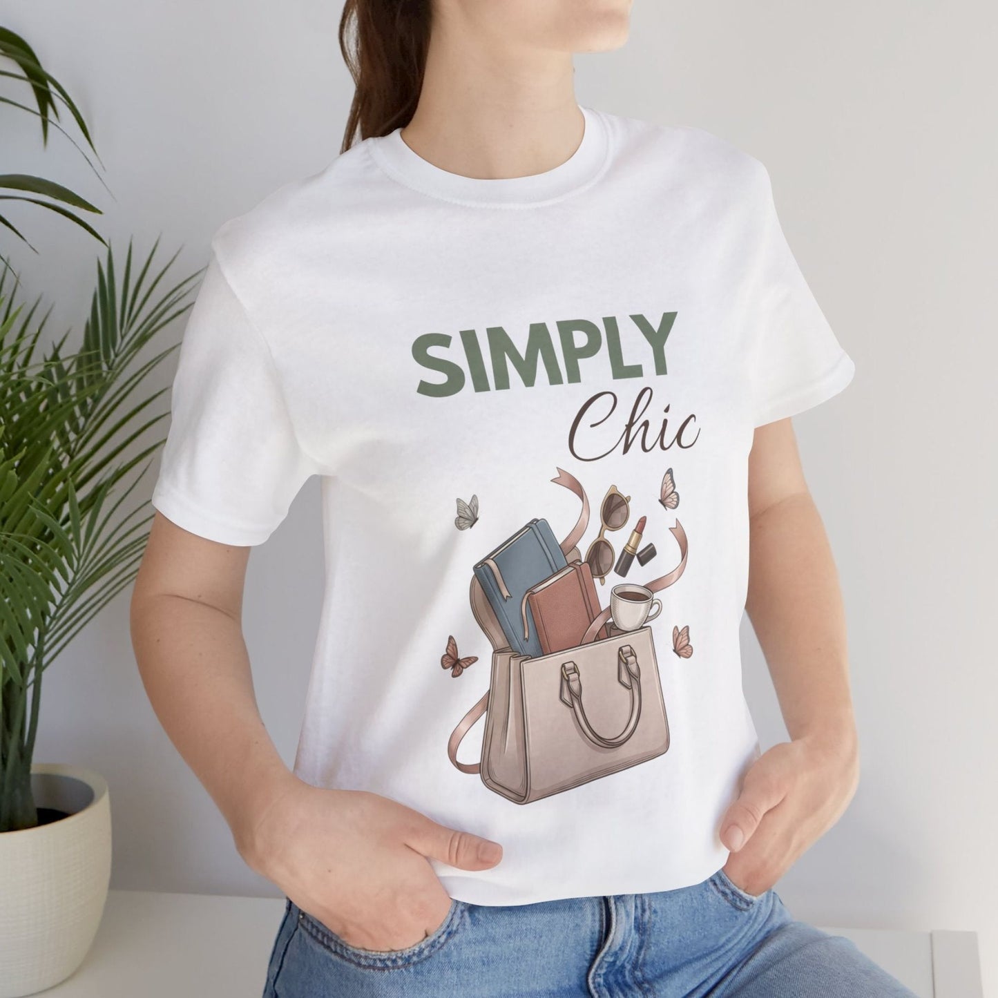 A woman is standing by a plant in a white t-shirt with 'SIMPLY Chic' on the front.