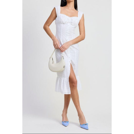 Woman wearing a white dress with a slit, holding a white handbag on a light gray background