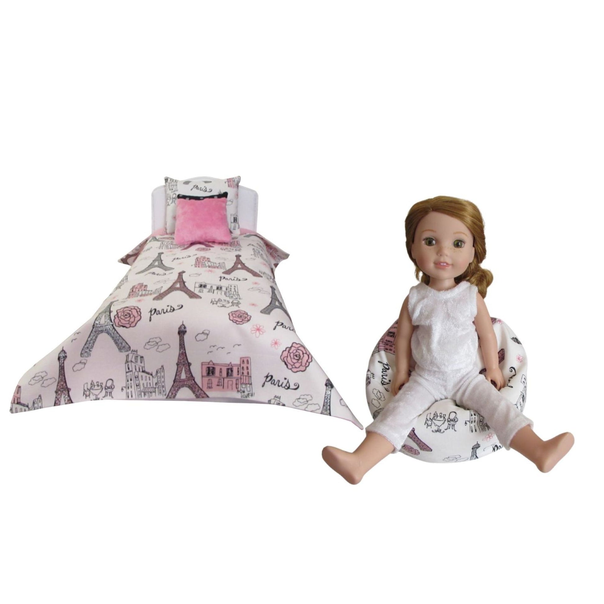 Doll with a Paris-themed bed set on a white background