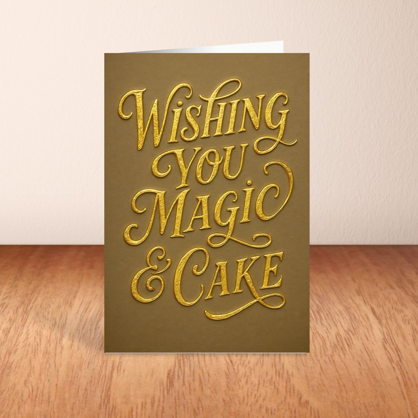 Greeting card with gold text 'Wishing you magic & cake' on a brown background